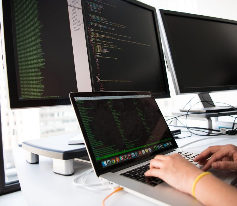 Persona programando en un portátil, desarrollo de software a medida